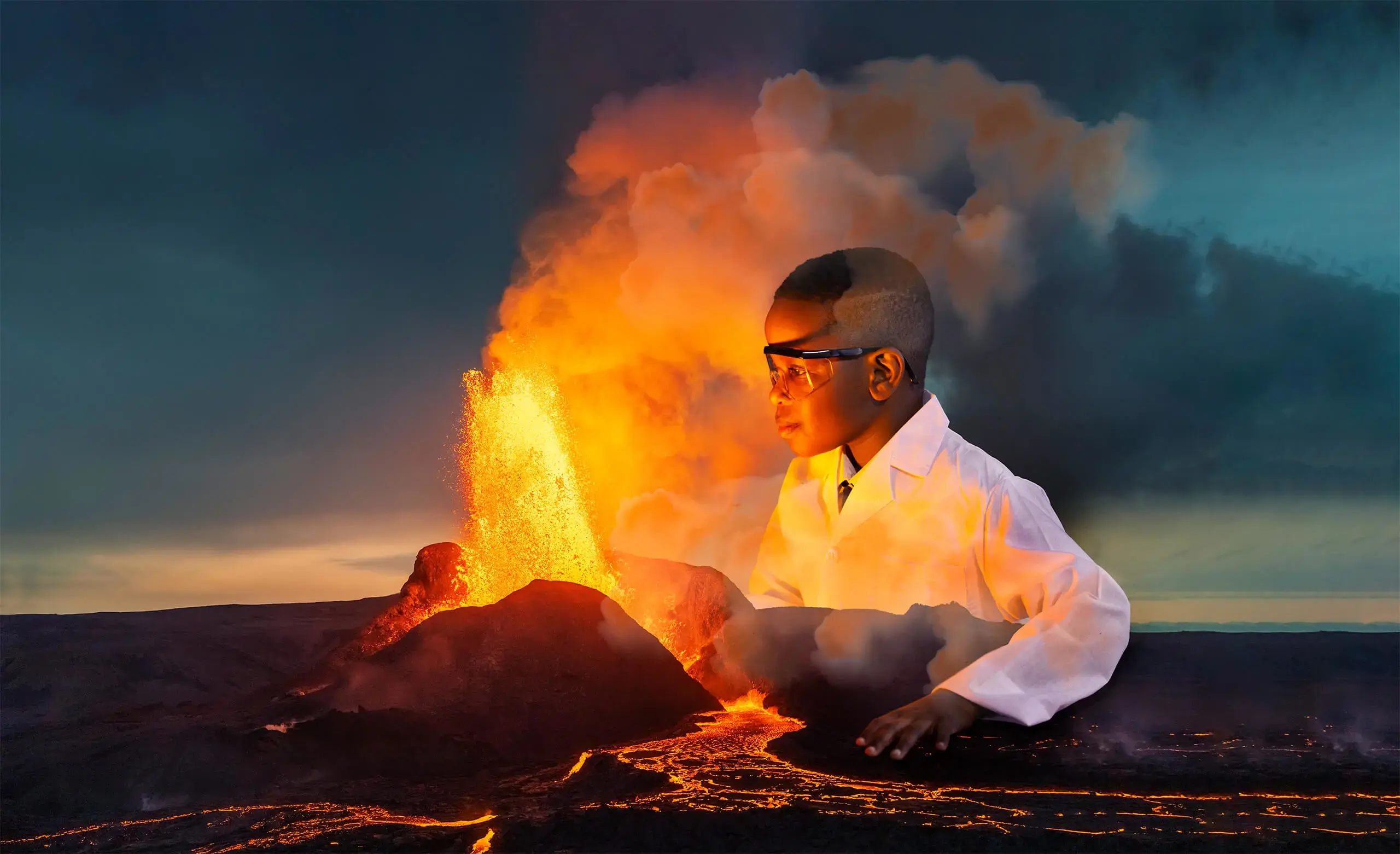 Composite image of pupil in lab coat and safety glasses sitting next to an erupting volcano